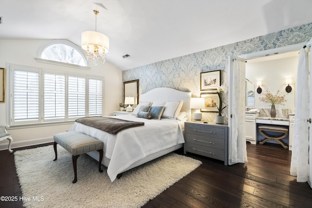 bedroom with wallpapered walls, a chandelier, dark wood finished floors, lofted ceiling, and baseboards