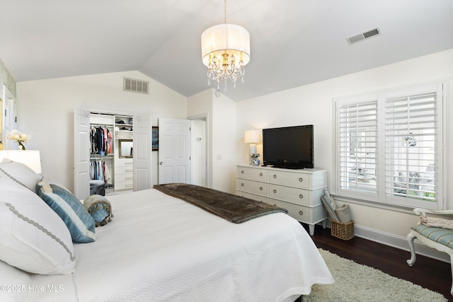 bedroom with wood finished floors, vaulted ceiling, a chandelier, baseboards, and a closet