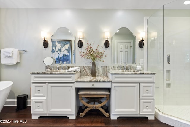 full bathroom with a shower stall, vanity, wood finished floors, and a freestanding bath