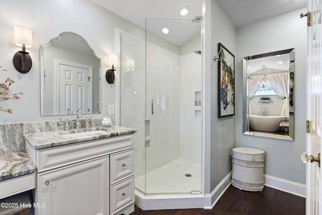 bathroom featuring a stall shower, wood finished floors, vanity, and baseboards