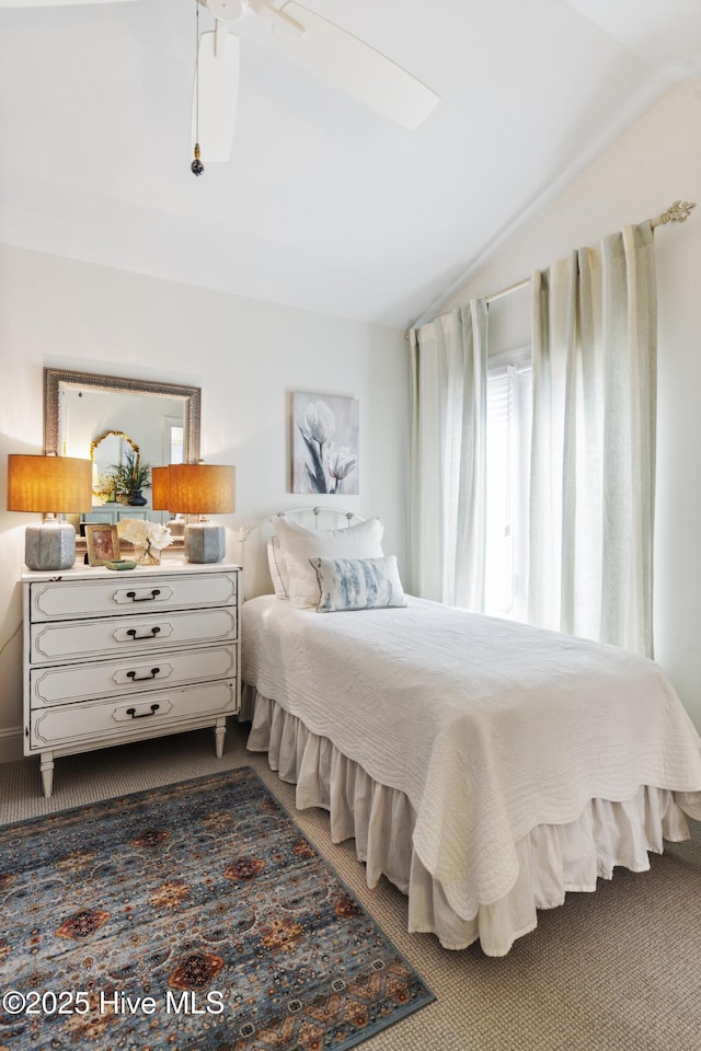 bedroom featuring lofted ceiling, carpet flooring, and a ceiling fan