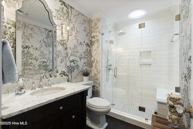 bathroom with ornamental molding, toilet, a shower stall, vanity, and wood finished floors