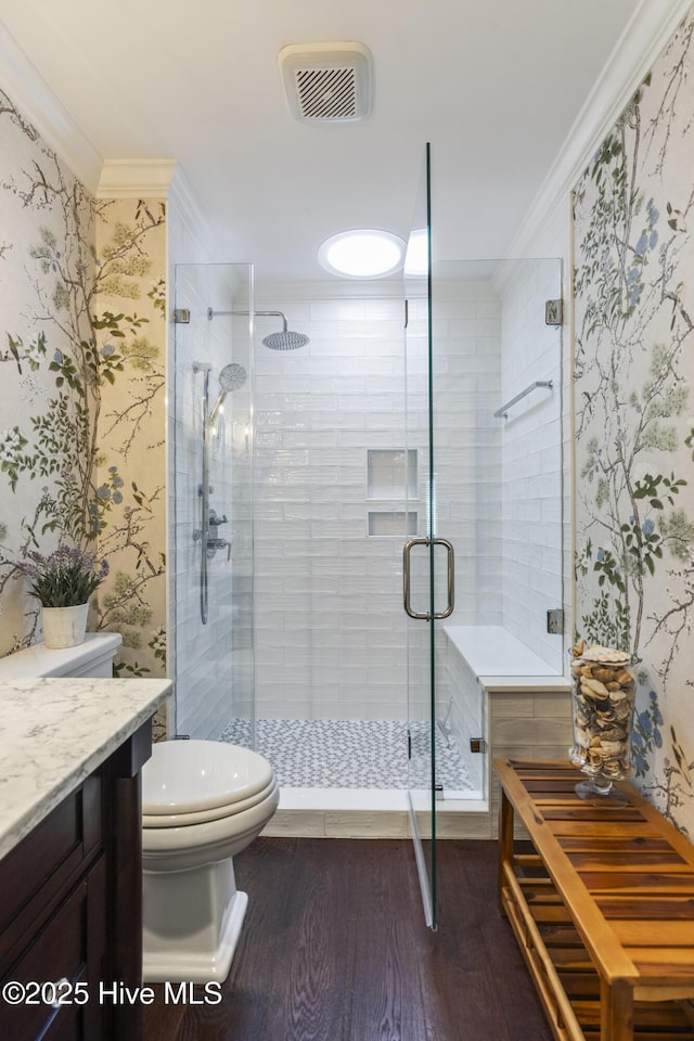 full bath featuring crown molding, wood finished floors, toilet, a shower stall, and vanity