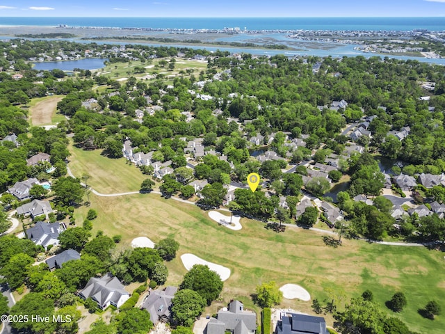 aerial perspective of suburban area with a nearby body of water, a local golf course, and a tree filled landscape