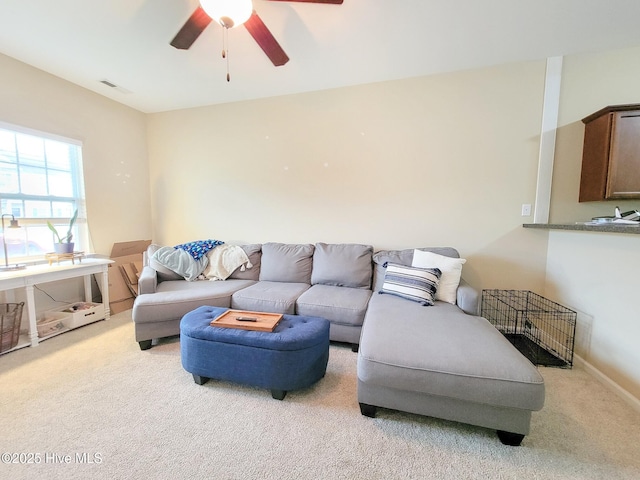 carpeted living room with ceiling fan