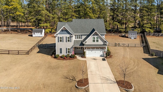 view of front of house with driveway, an attached garage, and fence