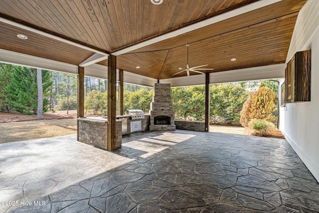 view of patio / terrace with a grill, ceiling fan, an outdoor stone fireplace, and an outdoor kitchen