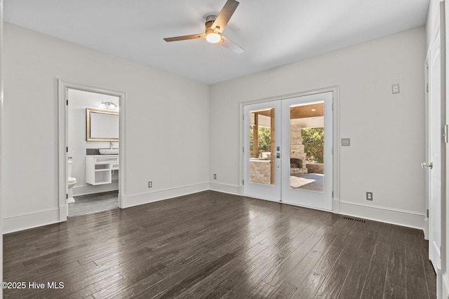 empty room with ceiling fan, dark hardwood / wood-style flooring, and french doors