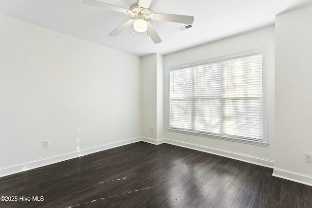 spare room featuring dark wood-type flooring and ceiling fan