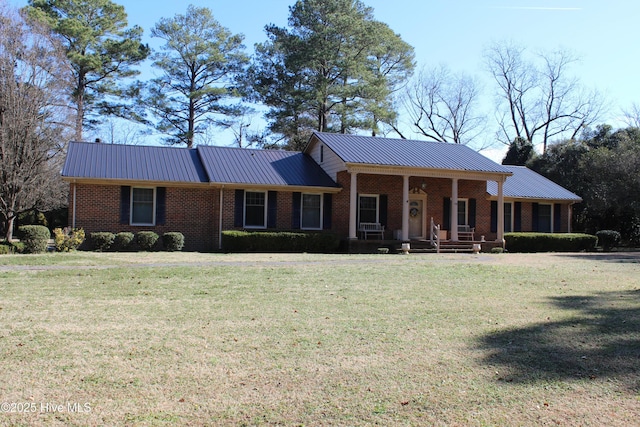 ranch-style home featuring covered porch and a front yard