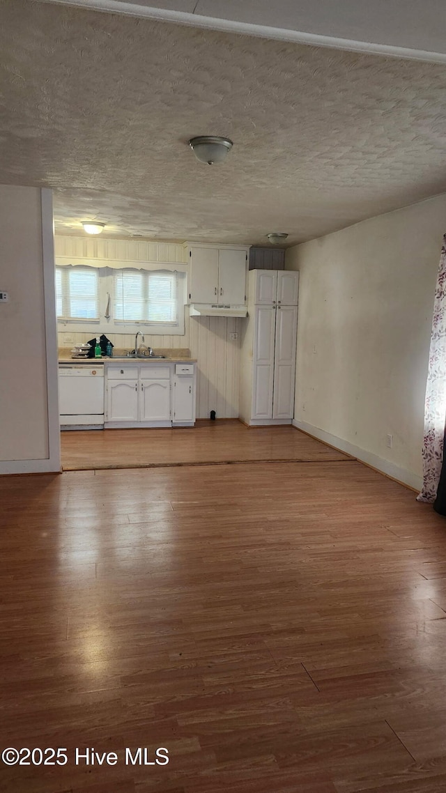 kitchen with baseboards, white dishwasher, light wood-style flooring, and white cabinets