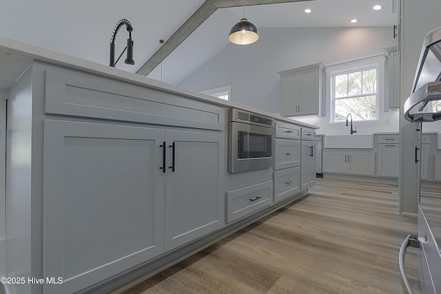 kitchen with sink, gray cabinetry, and stainless steel microwave