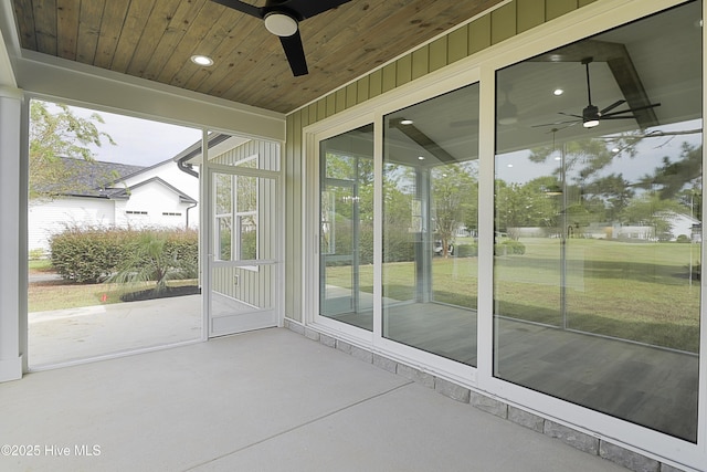 unfurnished sunroom featuring wood ceiling and ceiling fan