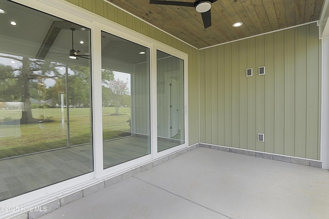 unfurnished sunroom featuring wood ceiling and ceiling fan