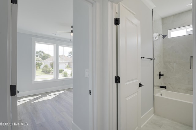 bathroom with tiled shower / bath, wood-type flooring, and ceiling fan