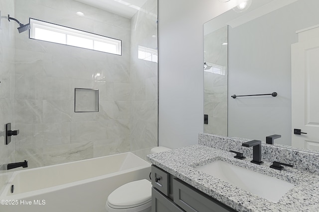 full bathroom with vanity, tiled shower / bath, and toilet