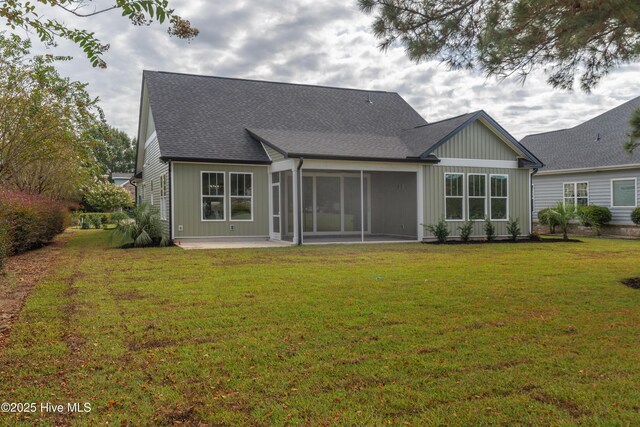 rear view of house featuring a sunroom, a yard, and a patio area