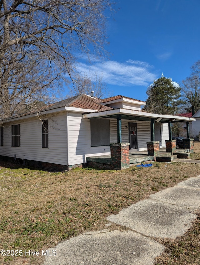 view of front of house featuring covered porch and a front lawn