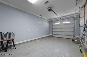 garage with visible vents, baseboards, and a garage door opener