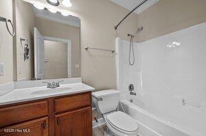 bathroom featuring toilet, bathtub / shower combination, and vanity