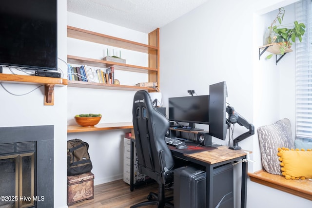 office with wood-type flooring and a textured ceiling