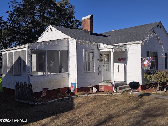 rear view of property featuring a sunroom