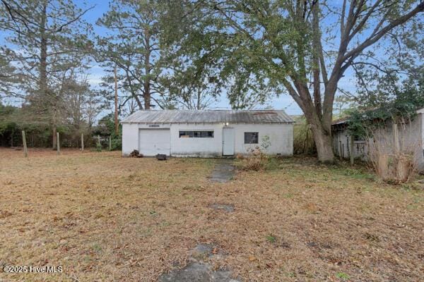 rear view of house featuring a yard and an outbuilding