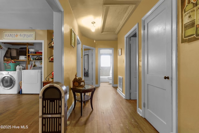 corridor with wood-type flooring and washer and clothes dryer