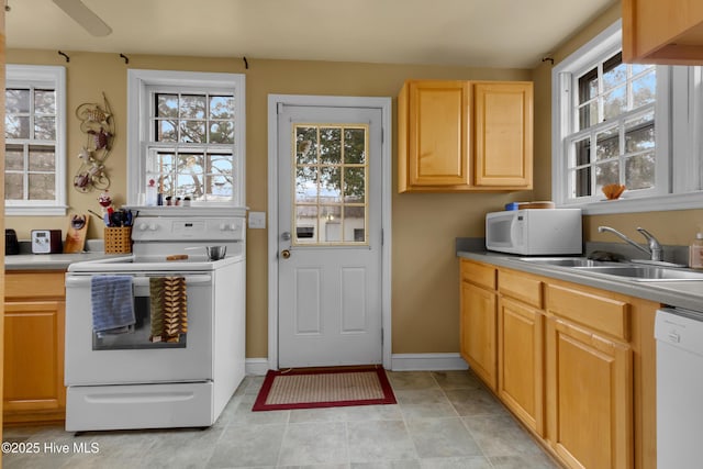 kitchen with sink, light brown cabinetry, and white appliances