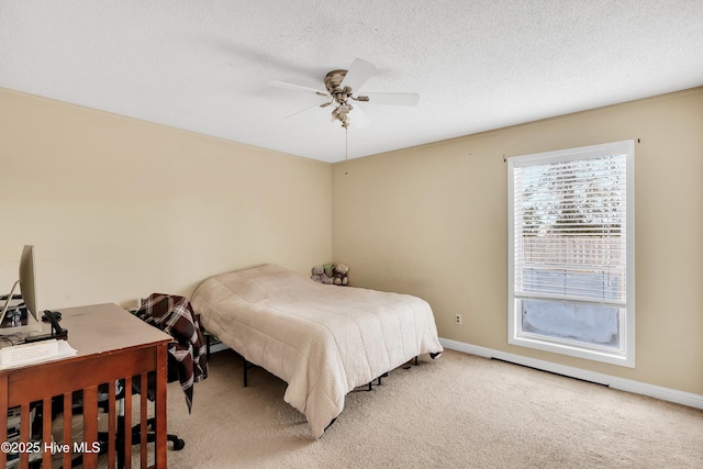 bedroom with ceiling fan, carpet floors, and a textured ceiling