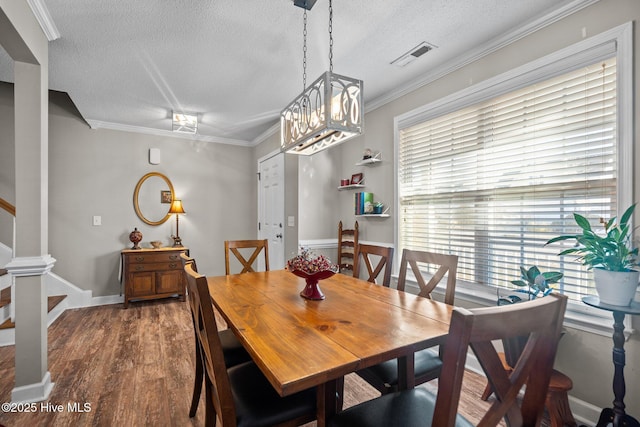 dining room with ornamental molding, dark hardwood / wood-style floors, and a textured ceiling