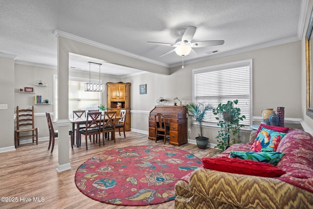 living room with ceiling fan, crown molding, a textured ceiling, and hardwood / wood-style floors