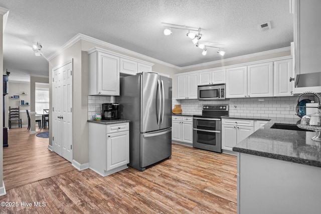 kitchen featuring white cabinetry, appliances with stainless steel finishes, sink, and light wood-type flooring