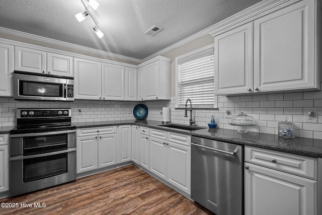 kitchen featuring white cabinetry, stainless steel appliances, sink, backsplash, and dark hardwood / wood-style floors