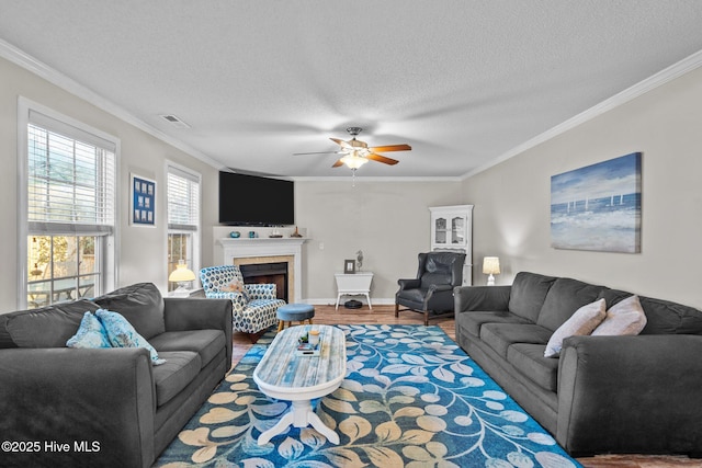 living room with crown molding, wood-type flooring, a tile fireplace, and a textured ceiling