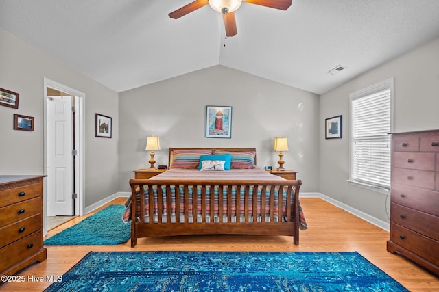 bedroom with light wood-type flooring and vaulted ceiling