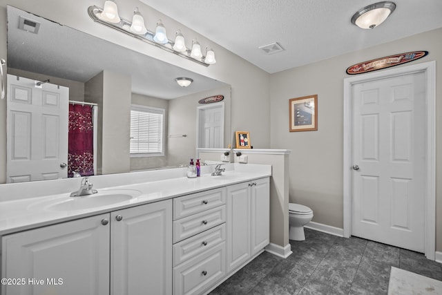 bathroom featuring vanity, a textured ceiling, and toilet