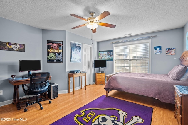 bedroom with hardwood / wood-style floors, ceiling fan, and a textured ceiling