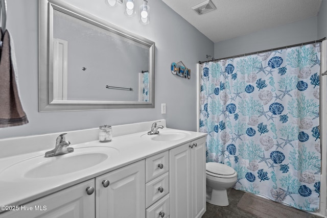 bathroom with vanity, curtained shower, toilet, and a textured ceiling