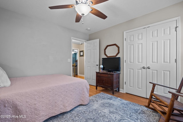 bedroom with a closet, hardwood / wood-style floors, and ceiling fan