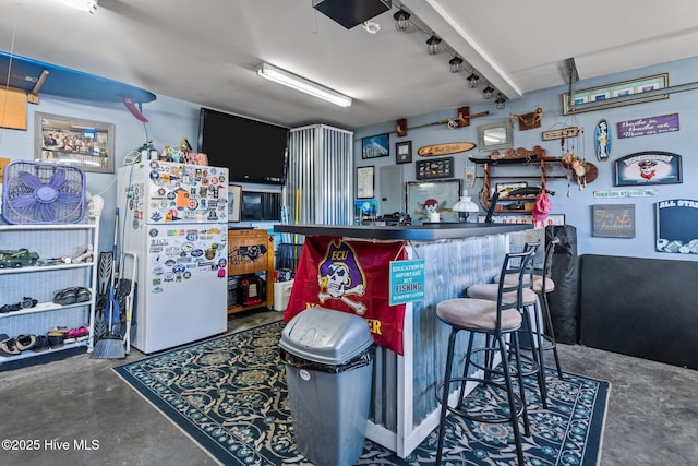 kitchen featuring white refrigerator with ice dispenser, kitchen peninsula, and concrete floors