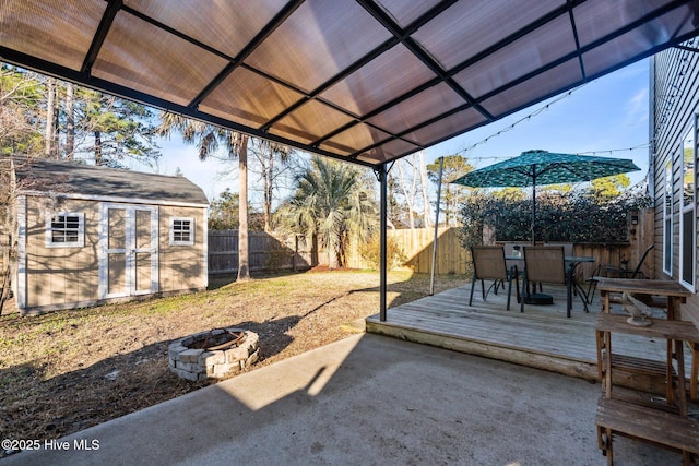 view of yard featuring a storage shed, a fire pit, and a wooden deck