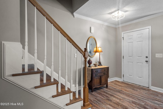 foyer entrance with crown molding, wood-type flooring, and a textured ceiling