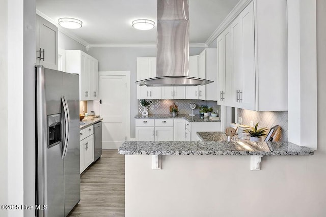 kitchen featuring crown molding, kitchen peninsula, island exhaust hood, stainless steel appliances, and white cabinets