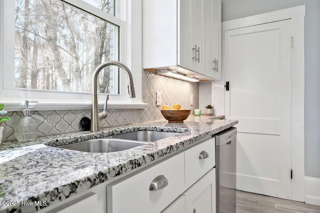 kitchen with sink, a wealth of natural light, dishwasher, and white cabinets