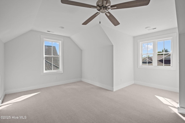 bonus room with vaulted ceiling, a healthy amount of sunlight, and light carpet