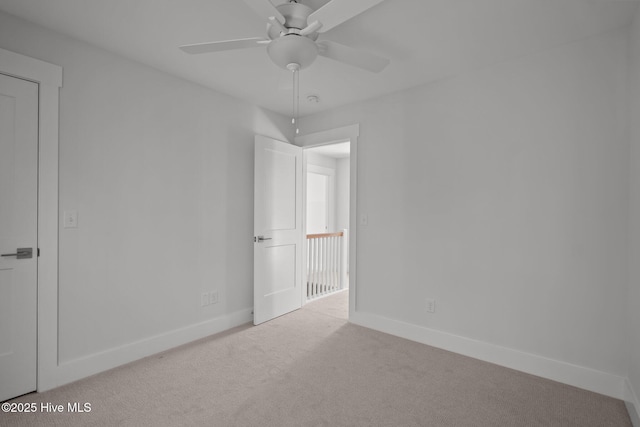 spare room featuring light colored carpet and ceiling fan