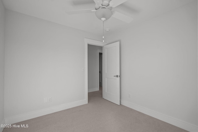 spare room featuring light carpet and ceiling fan