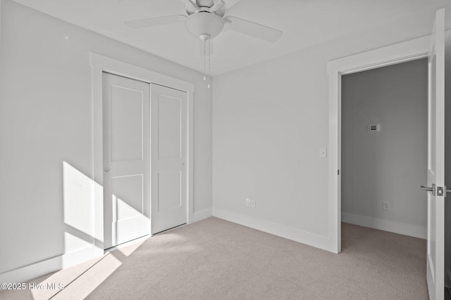 unfurnished bedroom with light colored carpet, ceiling fan, and a closet