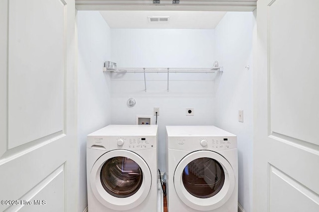 clothes washing area with washer and clothes dryer